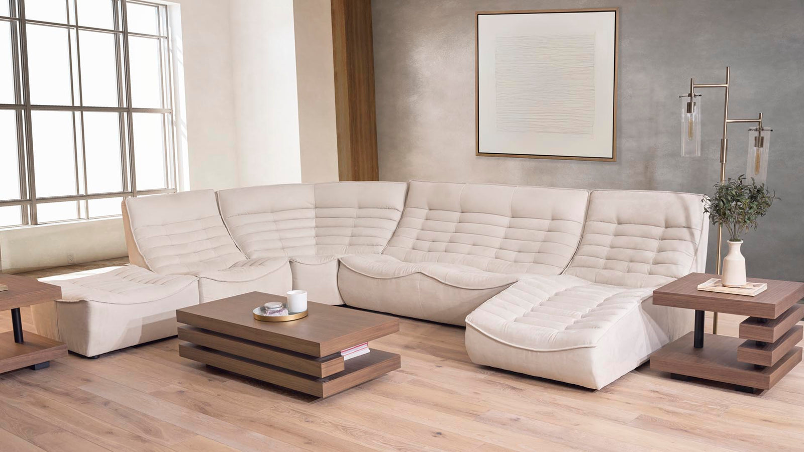 Photo of modern cream sectional (Diego) in a room with a lot of light, hardwood floors, and subtle art on the wall.