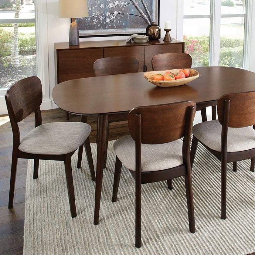 Dining room with wooden table and chairs in a well-lit room.